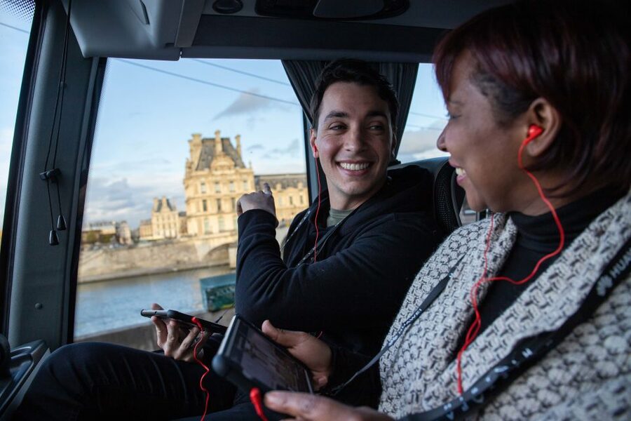 Paris: Audio-Guided Bus Tour & Seine River Cruise - The host and handsets: narration with music, not just facts